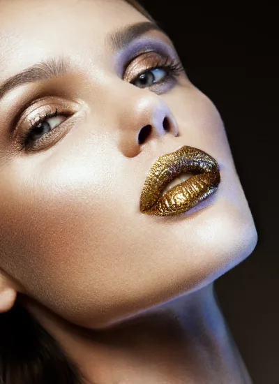 Beautyful girl with gold glitter on her face and body